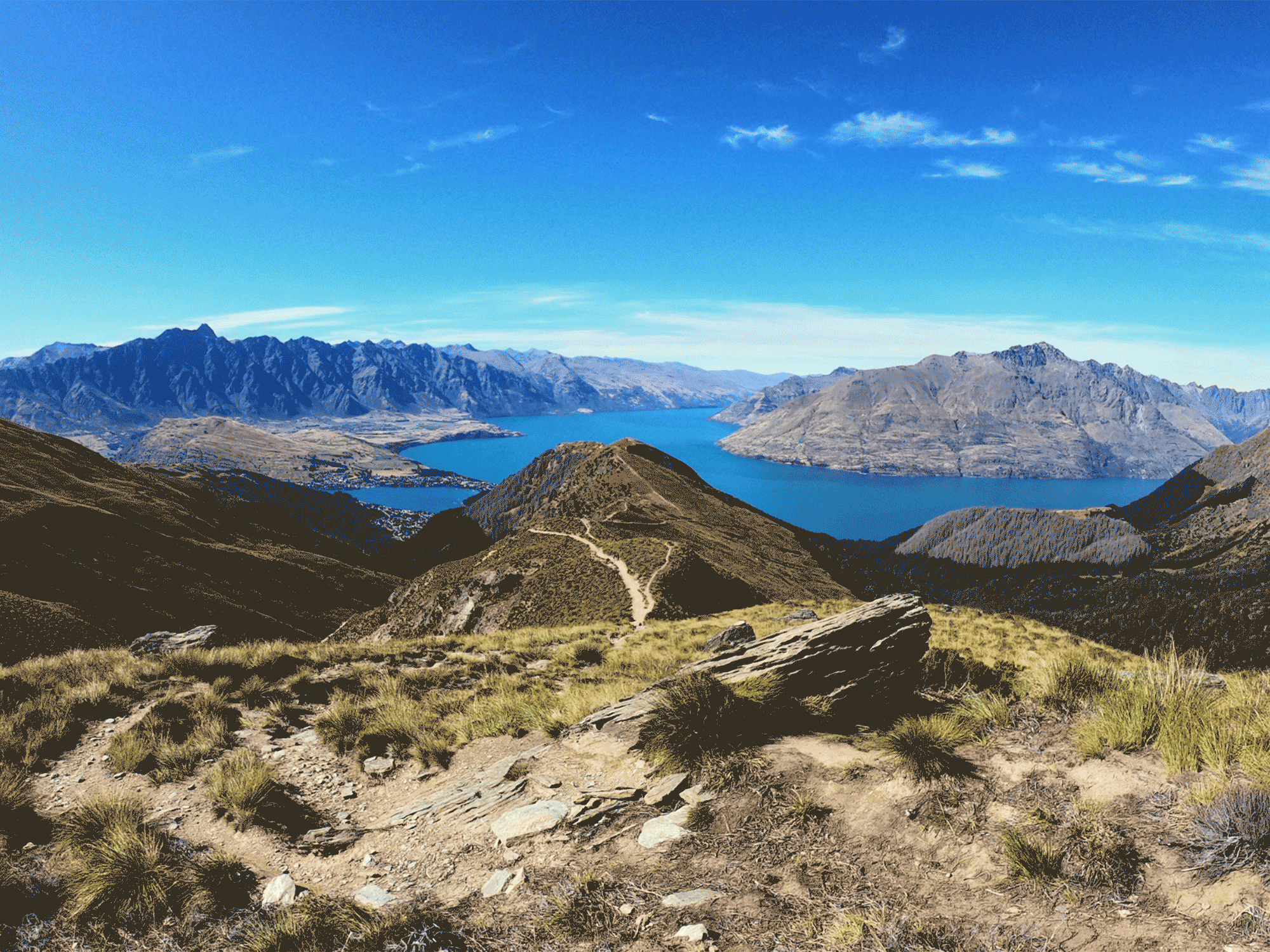 large mountains overlooking a body of water on a sunny day