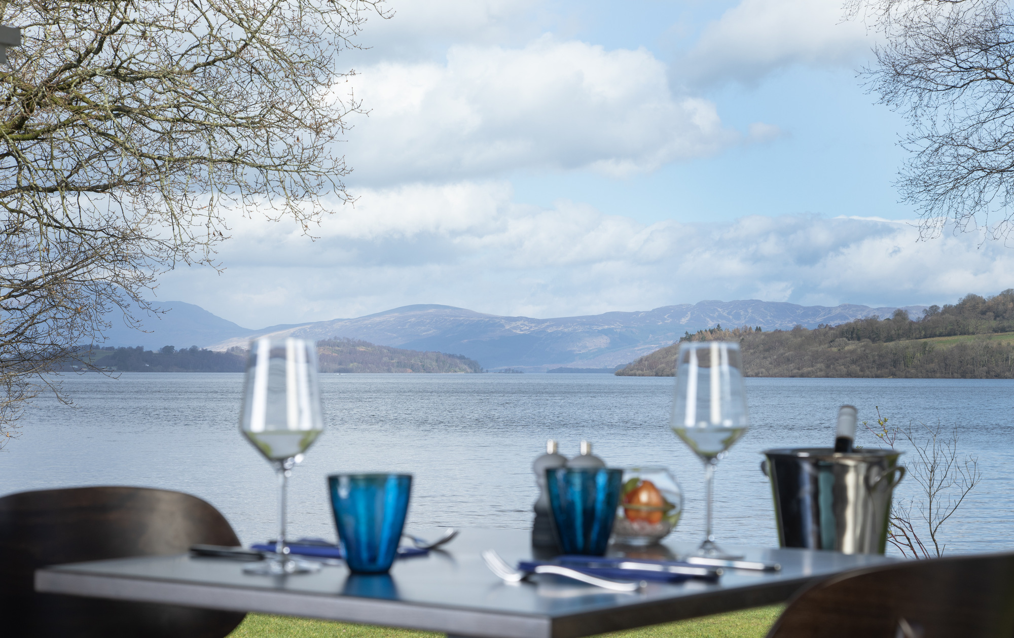 Dining table set with two glasses and a plate at La Vista restaurant by Loch Lomond.