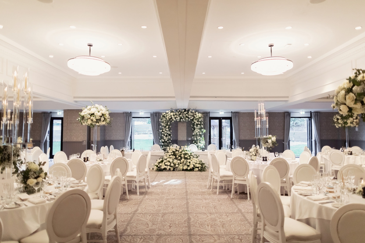 a walking space cleared out inside a wedding venue with tables and chairs on either side