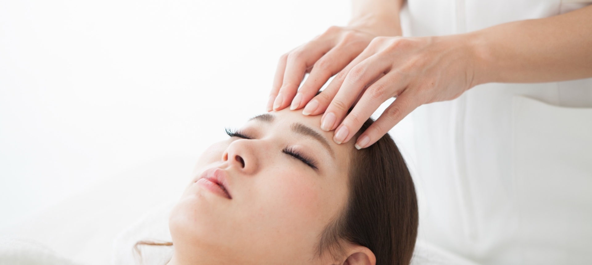 a woman laying on a table getting her forehead massaged