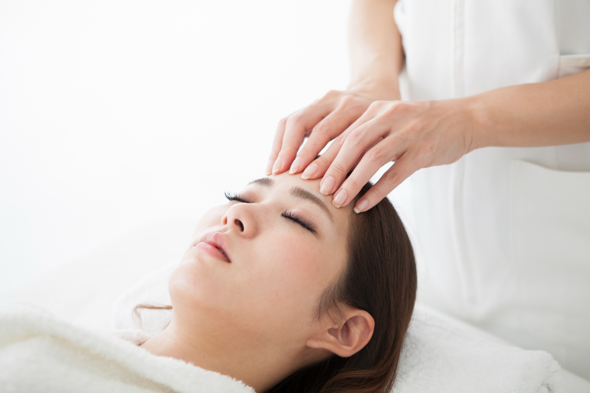 a woman laying on a table getting her forehead massaged