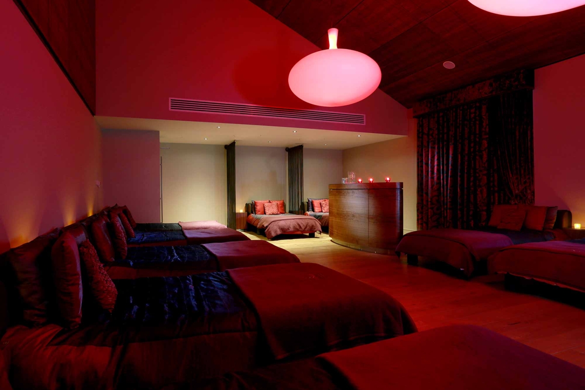 a relaxation room with beds and dark red lighting for relaxing