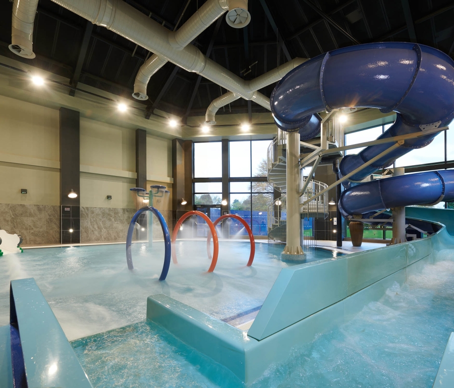 in door swimming pool with large water slide and rings in the middle