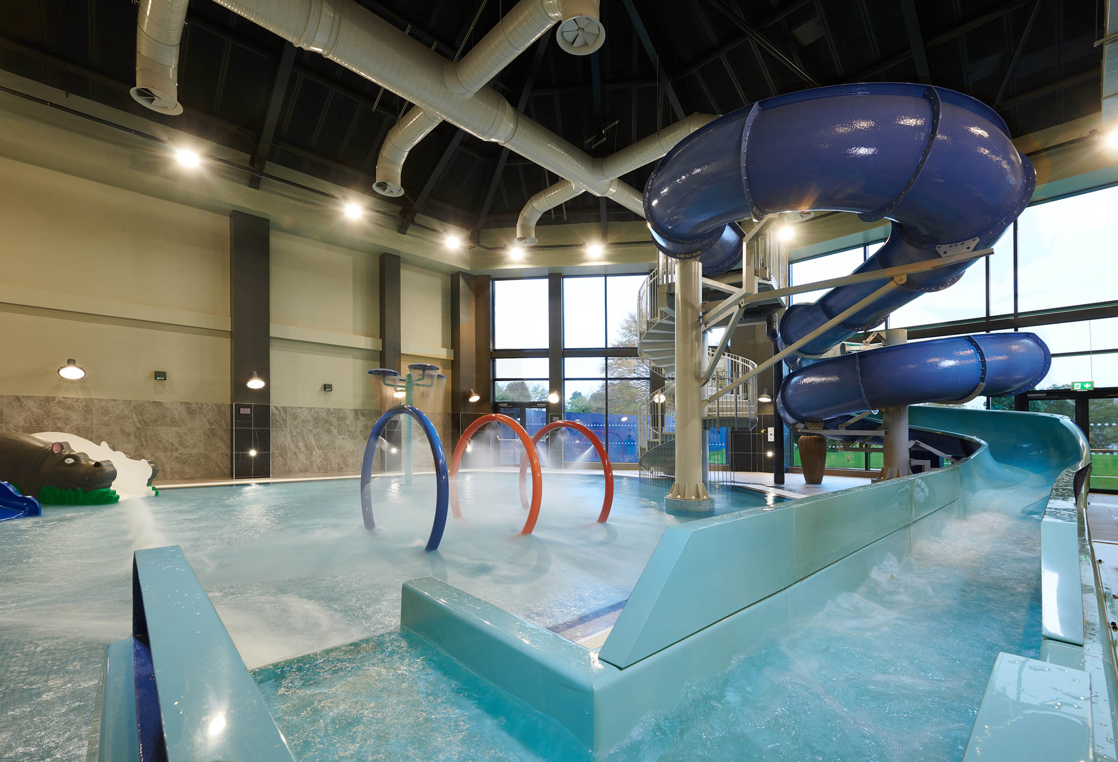 in door swimming pool with large water slide and rings in the middle