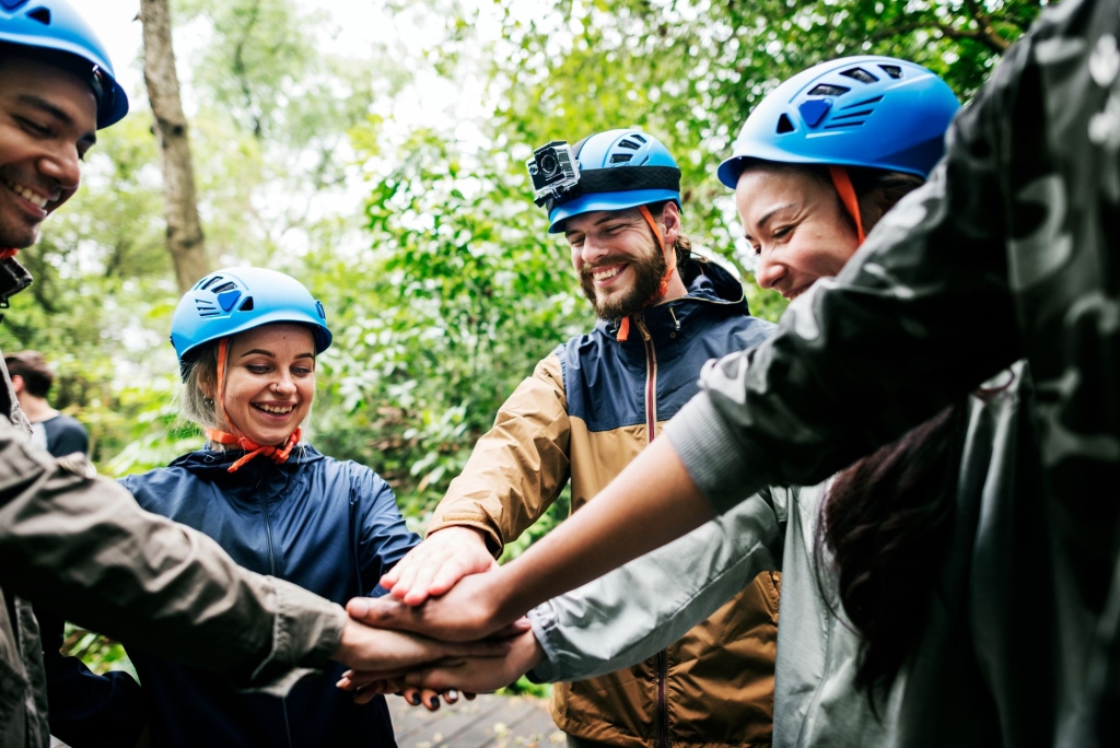 a group of people wearing blue helmets putting their hands together in the middle of a circle