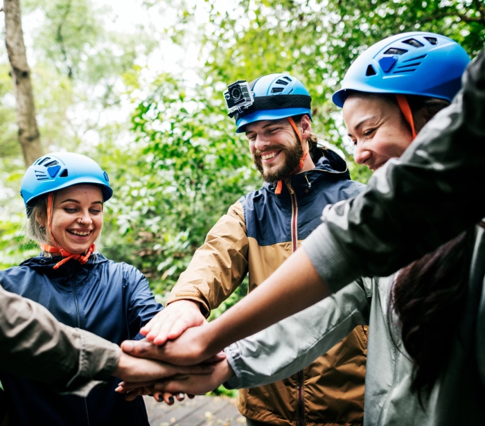 a group of people wearing blue helmets putting their hands together in the middle of a circle