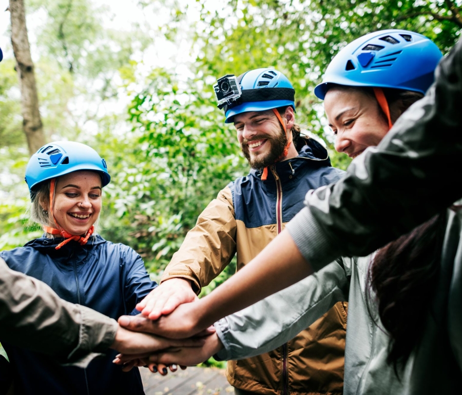 a group of people wearing blue helmets putting their hands together in the middle of a circle