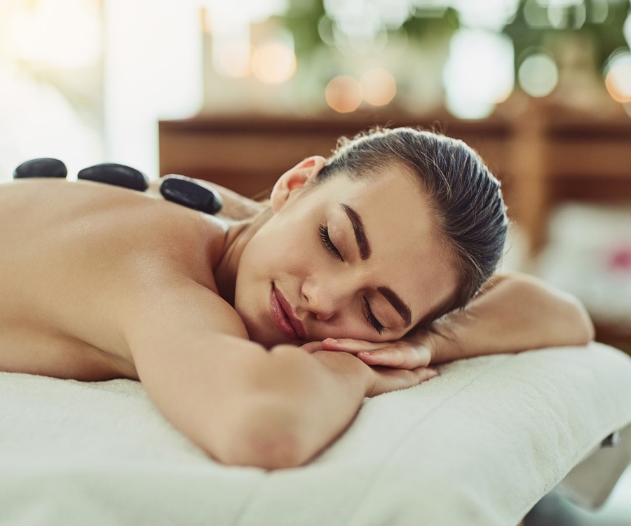 a woman lying face down on a spa table