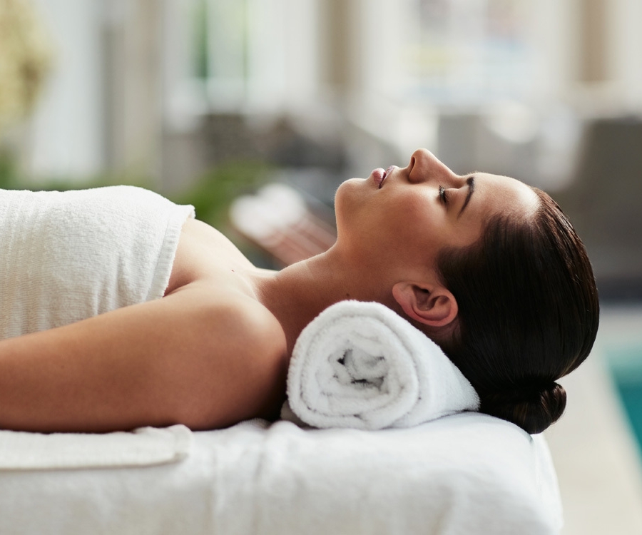 a woman lying back down on a spa table