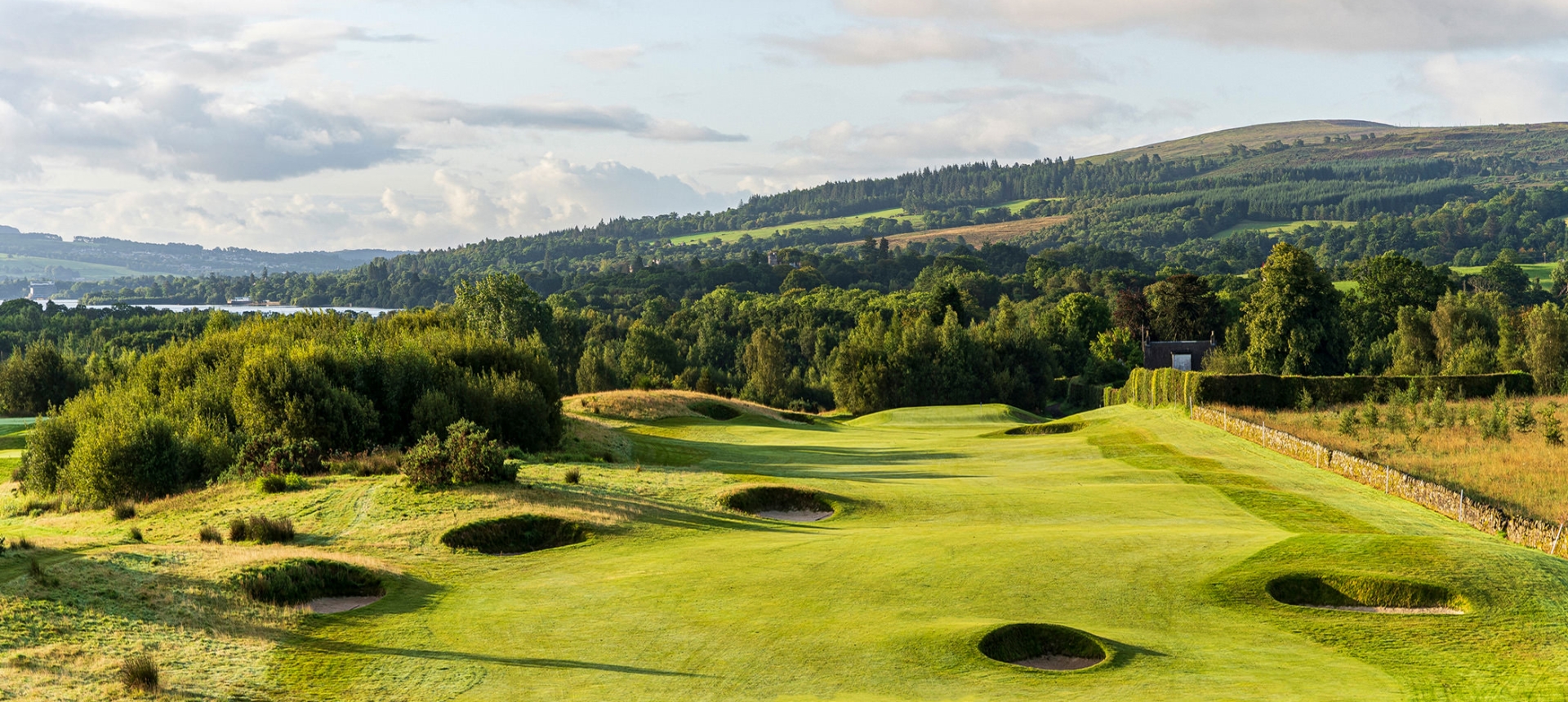 a golf course with multiple sand dunes and trees surrounding the course