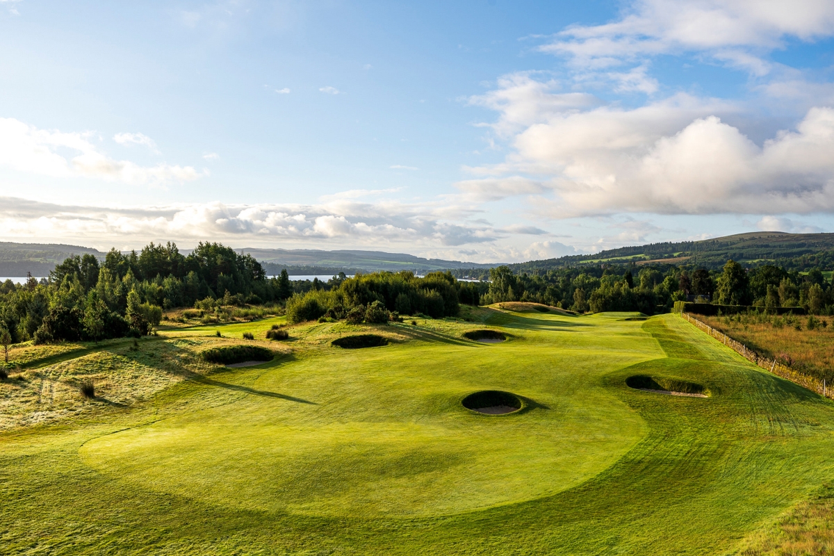 golf course with sand pits throughout on with clouds in the sky above