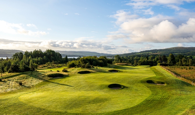 golf course with sand pits throughout on with clouds in the sky above