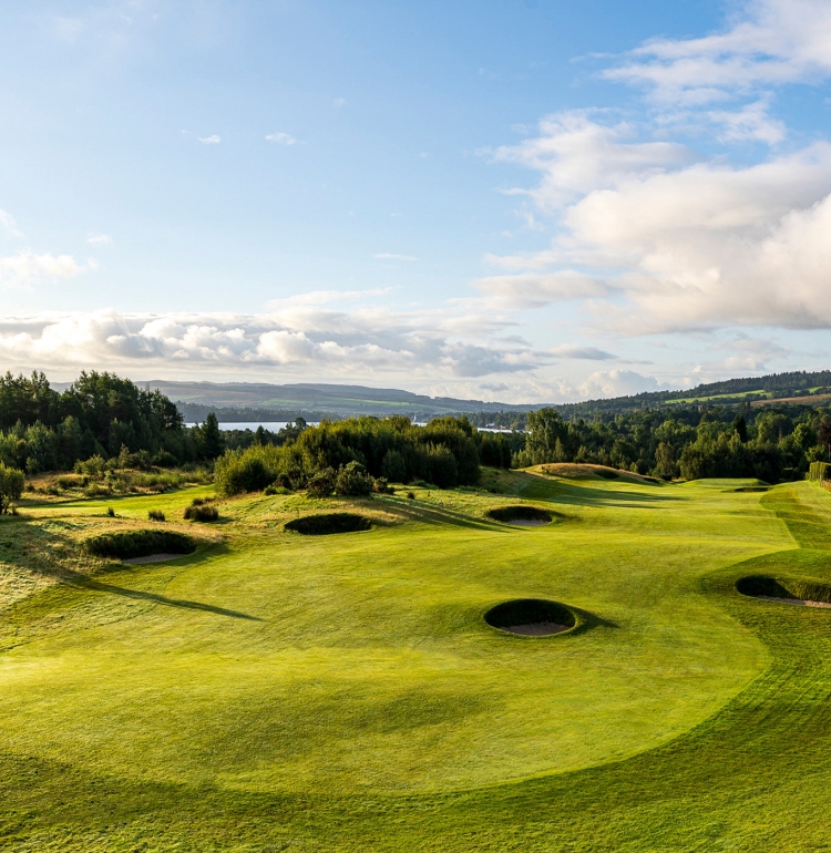 golf course with sand pits throughout on with clouds in the sky above