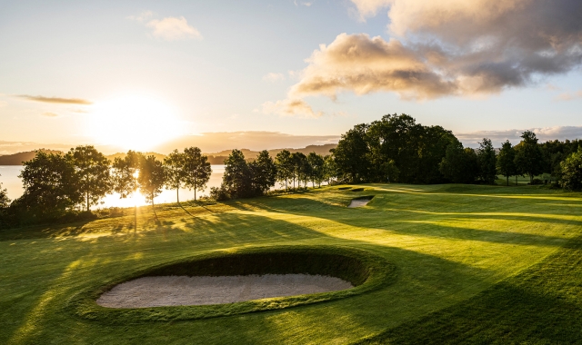 golf course with large sand pits with the sun setting behind it