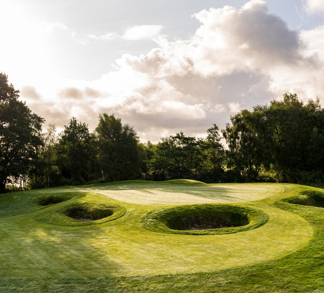 golf course with multiple large sand pits and cloudy skies