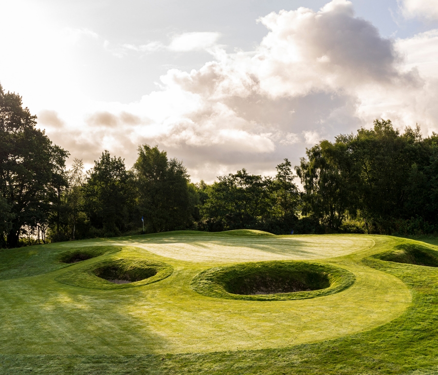 golf course with multiple large sand pits and cloudy skies