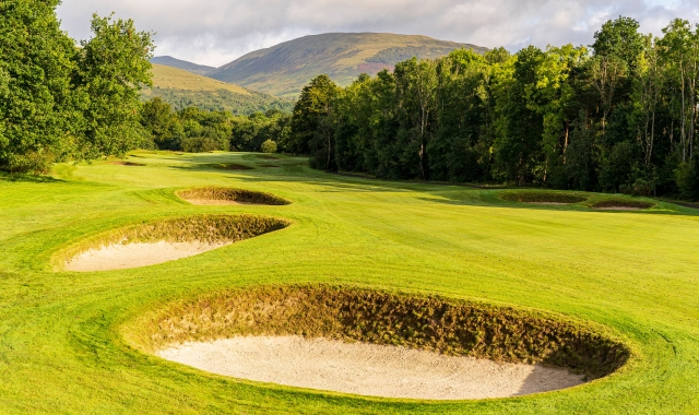 a golf course with multiple sand pits on a sunny day