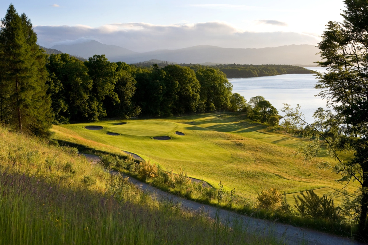 view of a golf course from a hill side with a trail in between