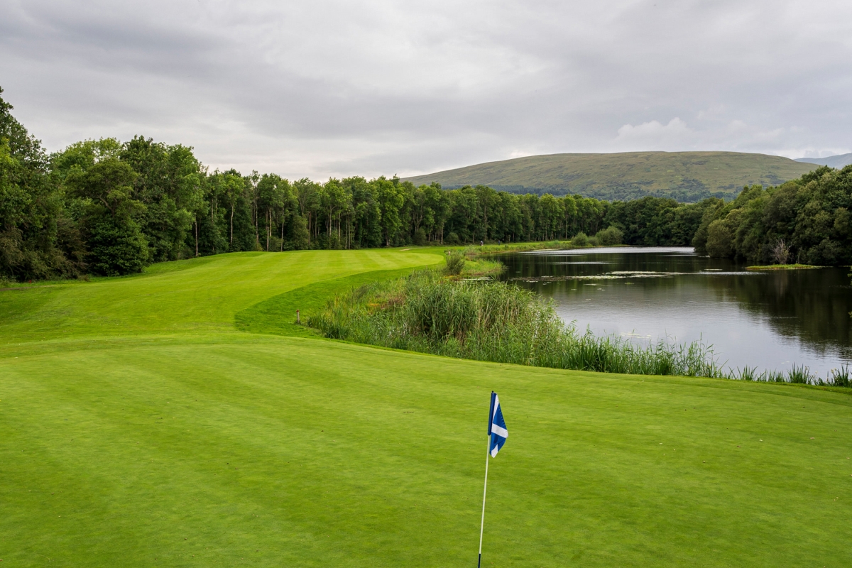 golf course with a flag sticking up from the hole surrounded by water