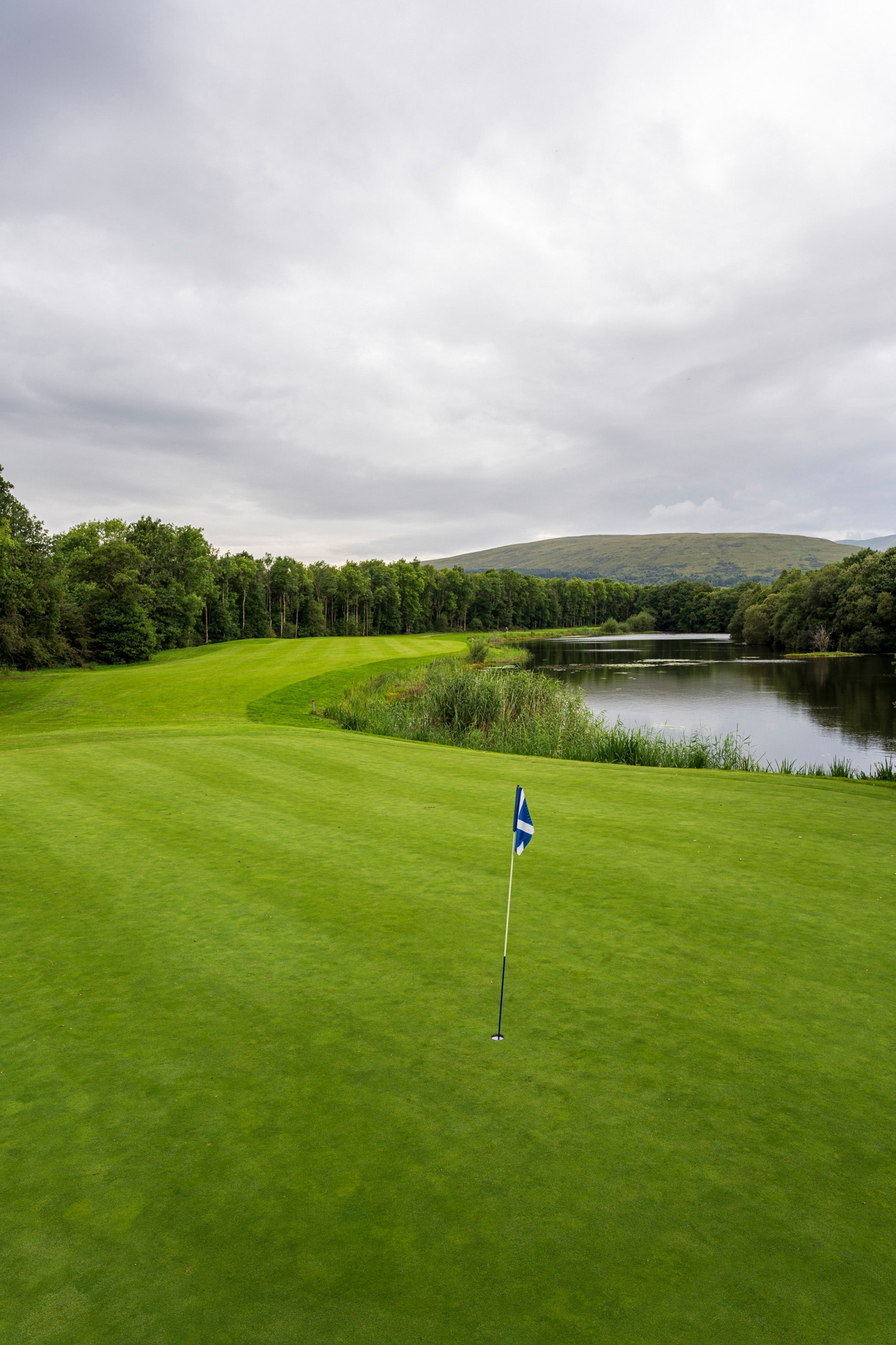 golf course with a flag sticking up from the hole surrounded by water