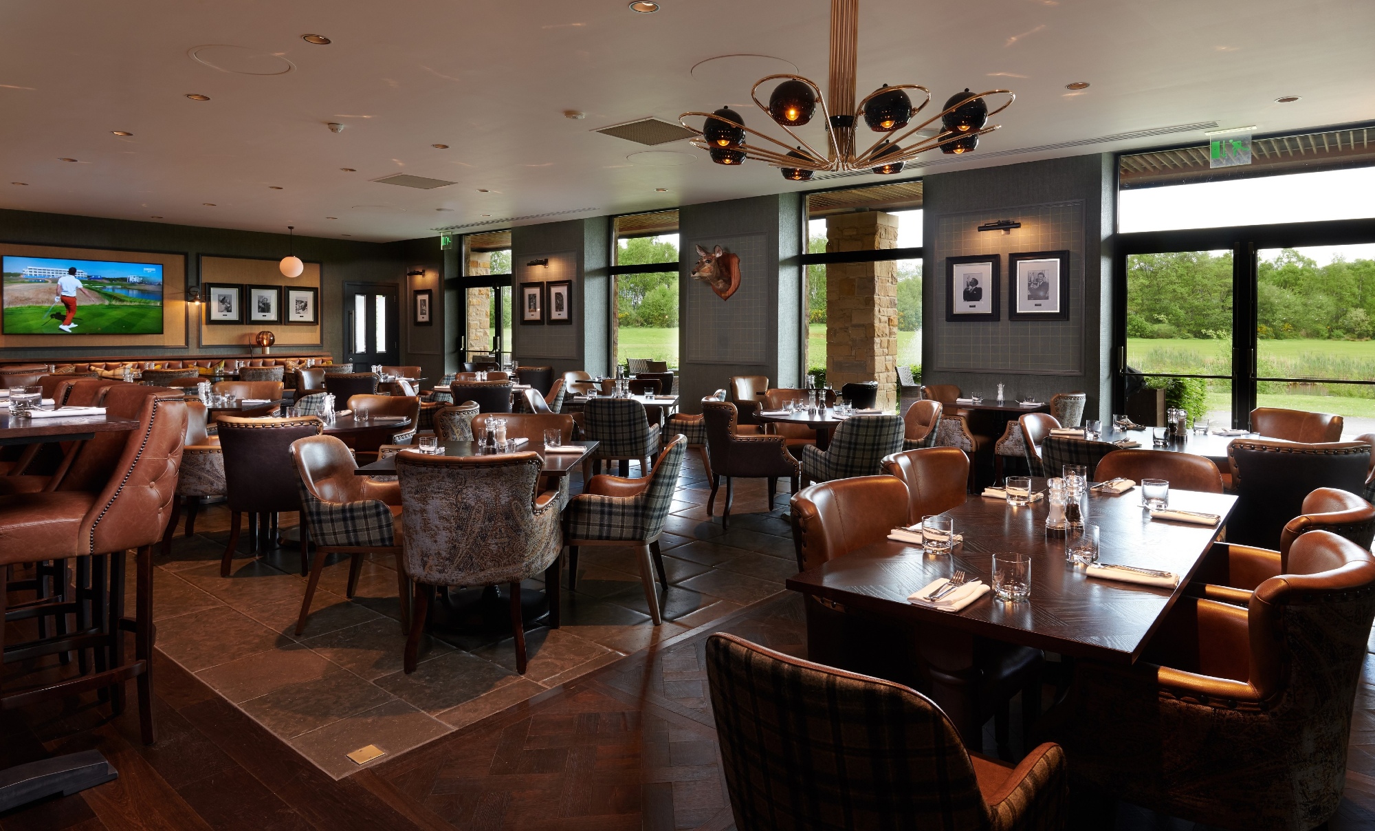 chairs and tables in a dining room with windows showing the outdoor greenery