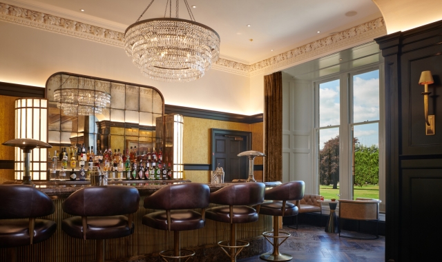 a bar with seating next to a window showing the bright green outside views