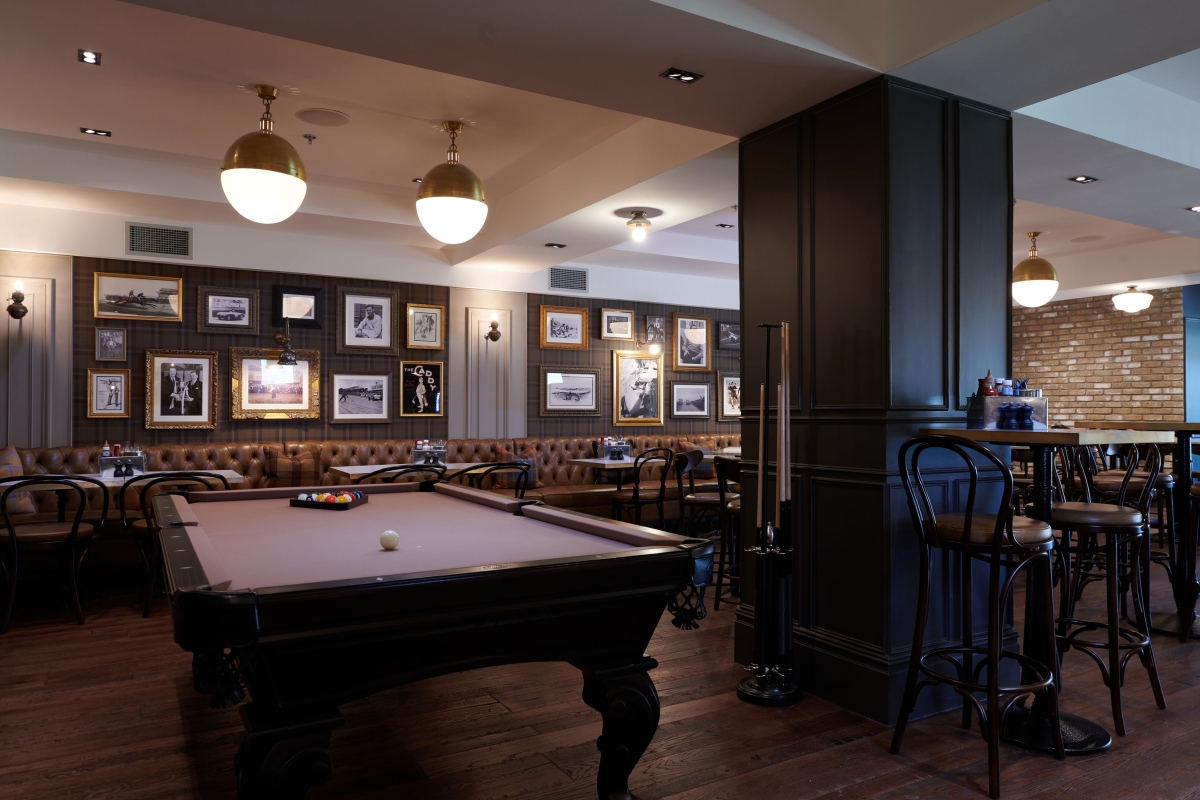 pool table in front of some seating areas with pictures on the wall in the back