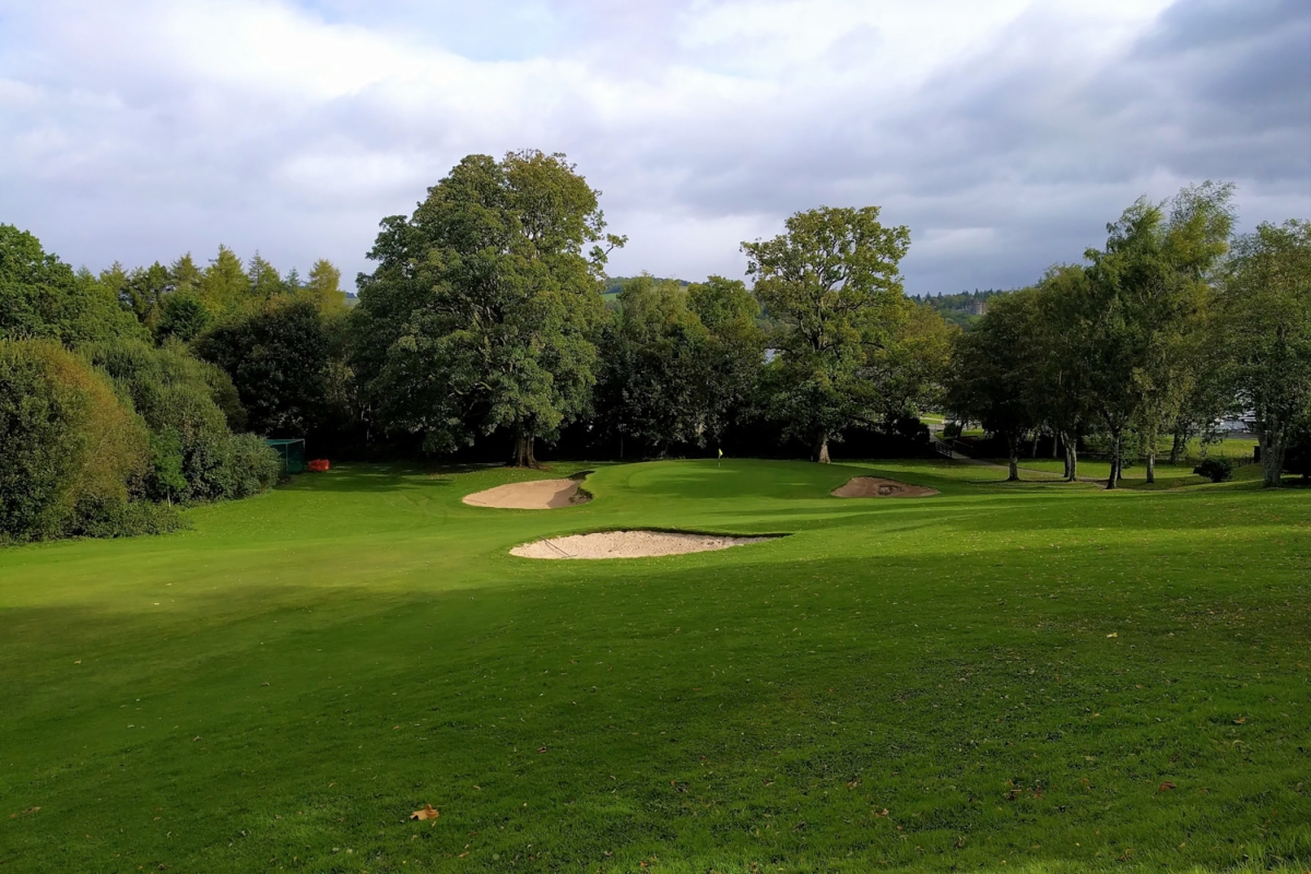 golf course with sand pits surrounding the hole and trees along the edges