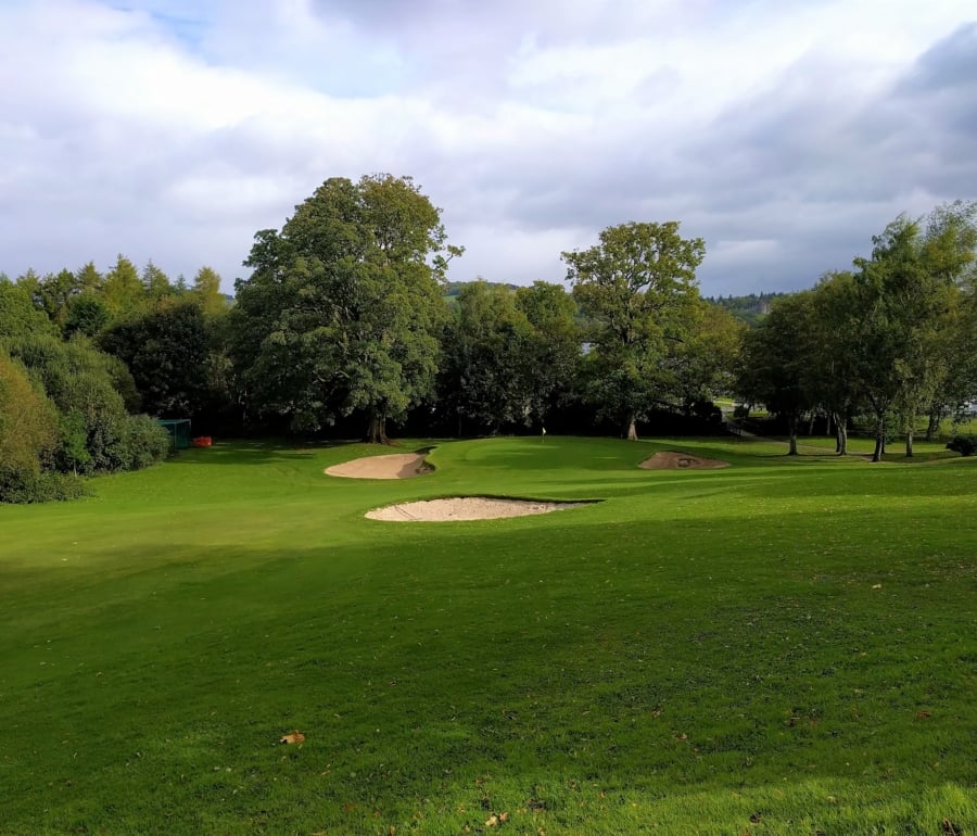 golf course with sand pits surrounding the hole and trees along the edges