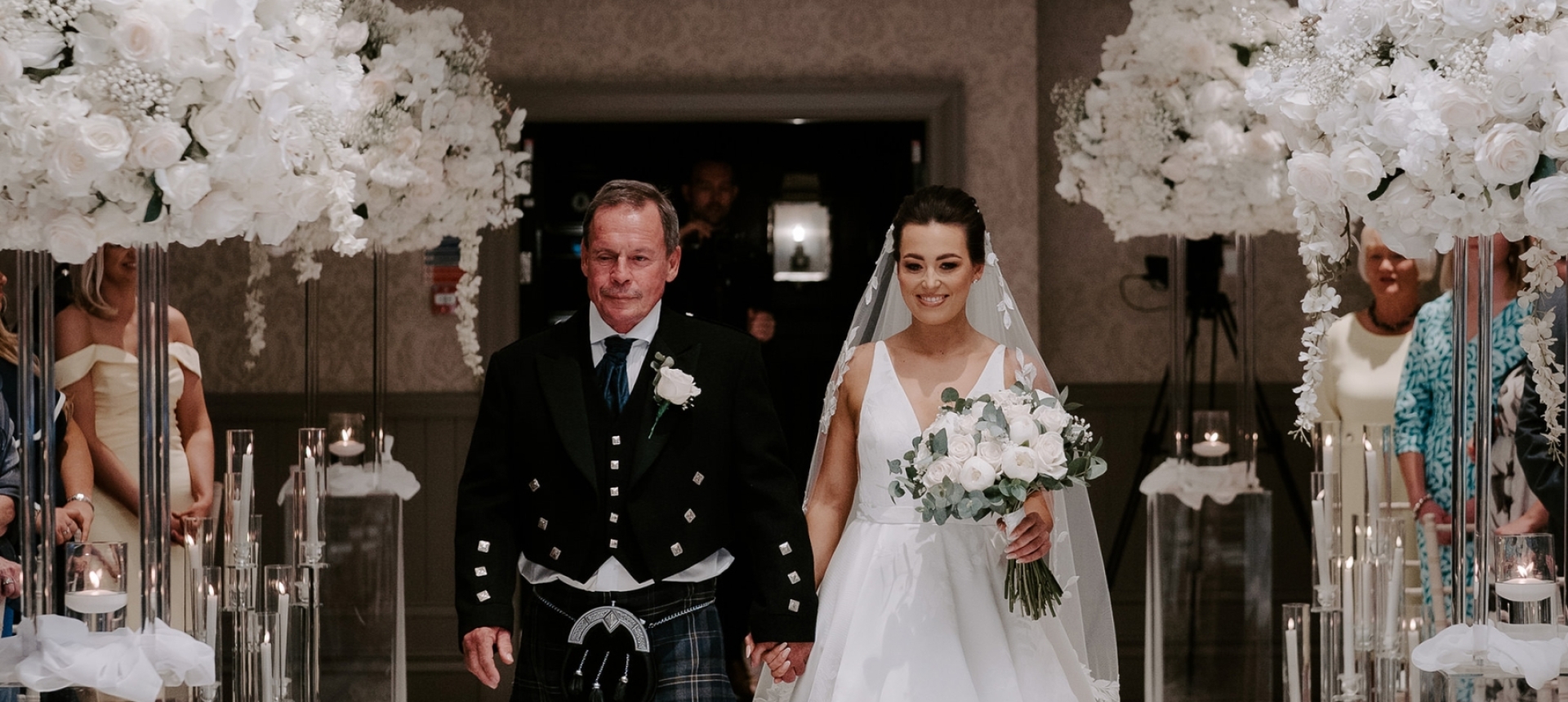 a bridge and groom walking down the aisle holding hands