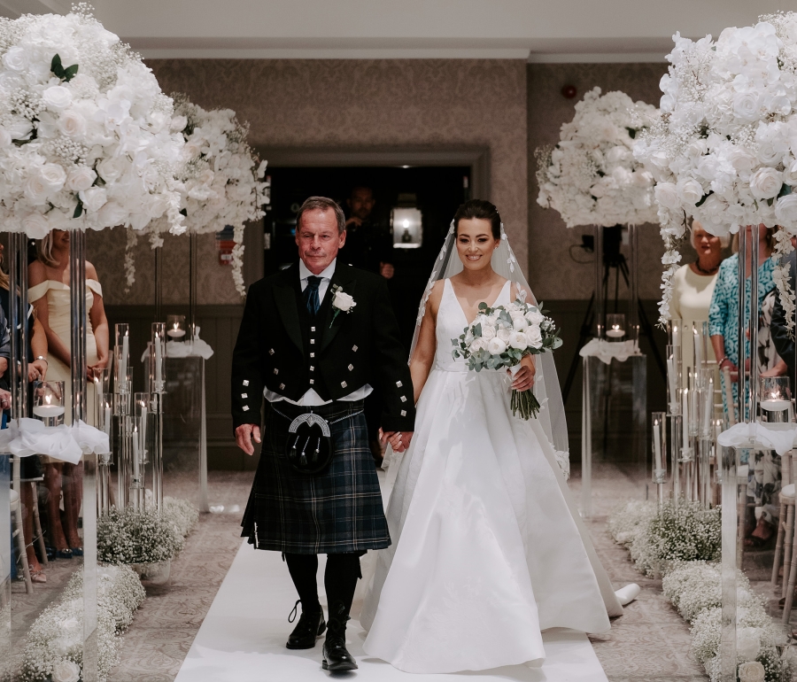 a bridge and groom walking down the aisle holding hands