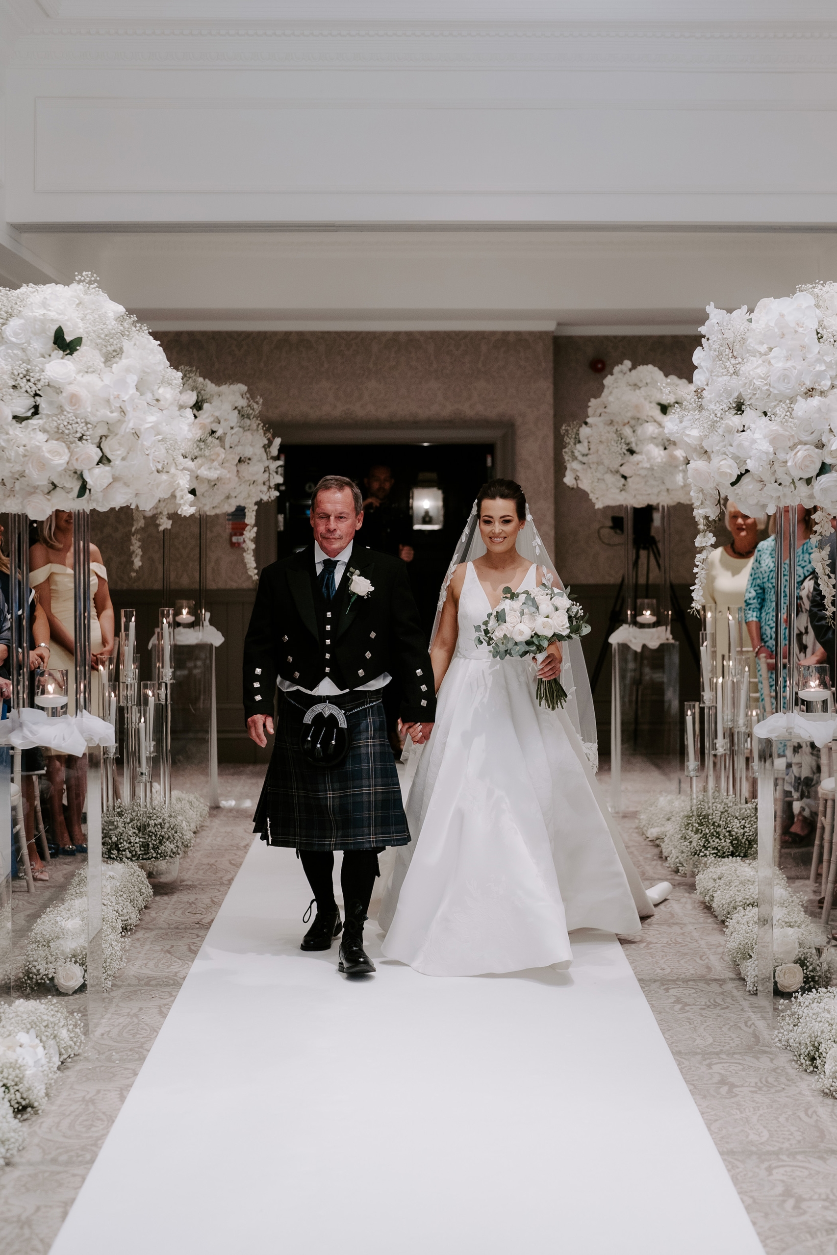 a bridge and groom walking down the aisle holding hands