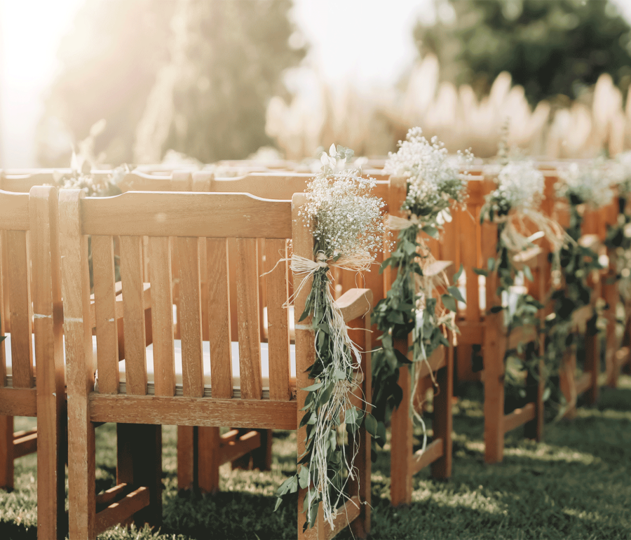 rows of wooden chairs set up outside on the grass
