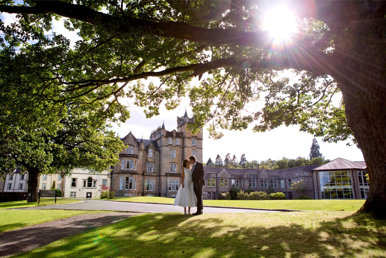 A bride and groom kissing under a tree at the Cameron House.