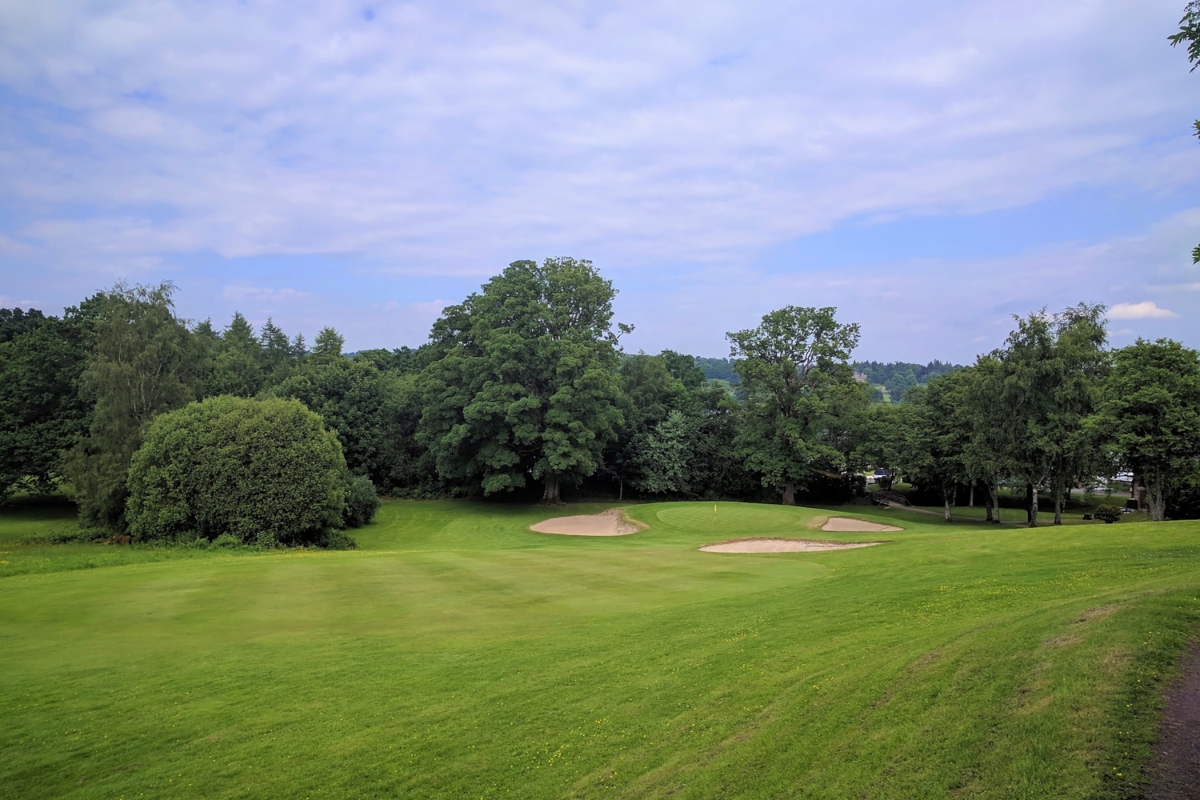 golf course with sand dunes around the hole on a cloudy day