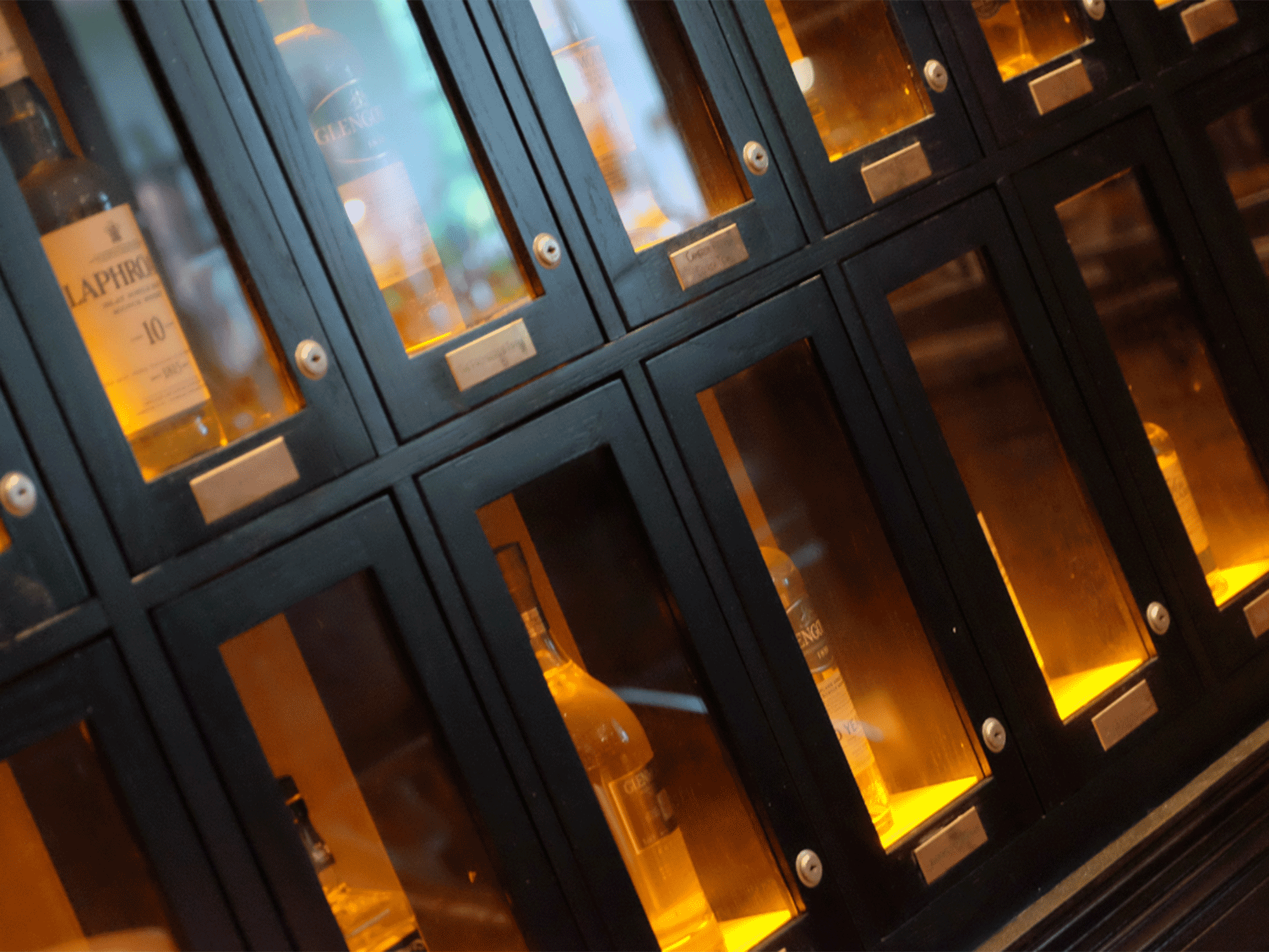 close up view of bottles of whiskey sitting inside a locked case