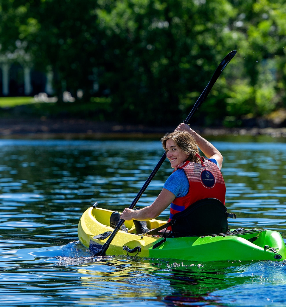 a woman looking back while paddling a canoe on the water