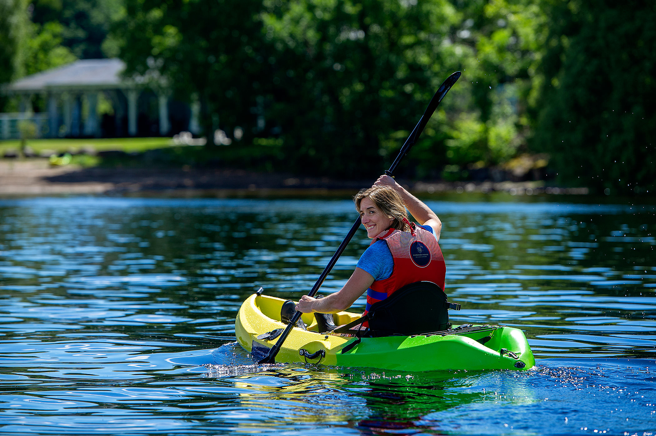 a woman looking back while paddling a canoe on the water