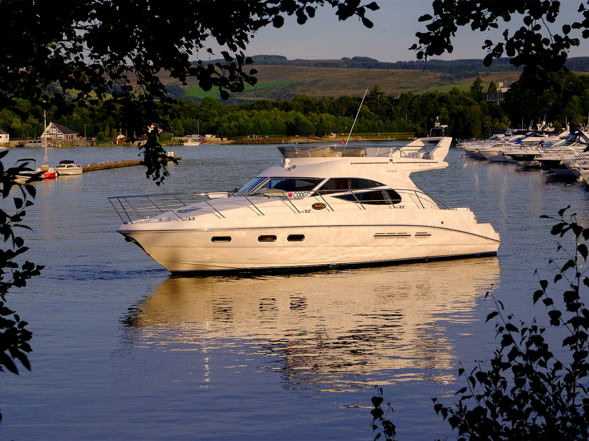 a white boat sitting on the water in a marina