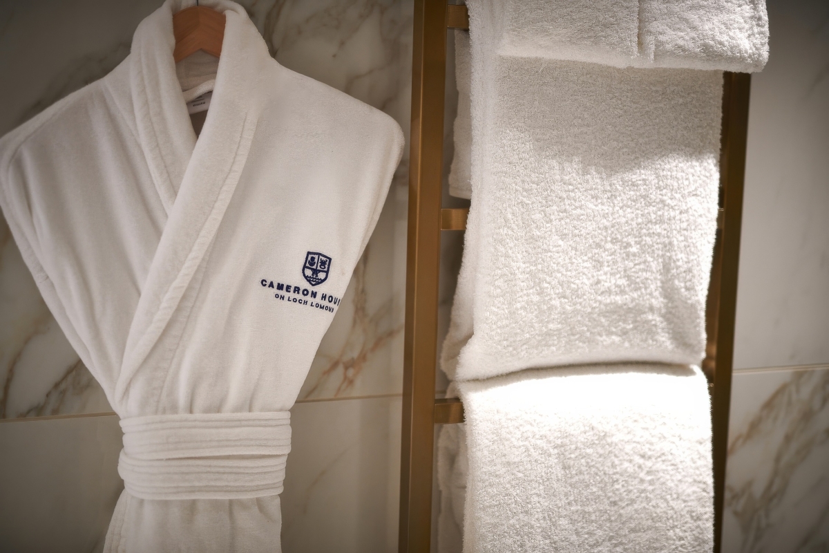 A white Cameron House branded bathrobe and fluffy white towels