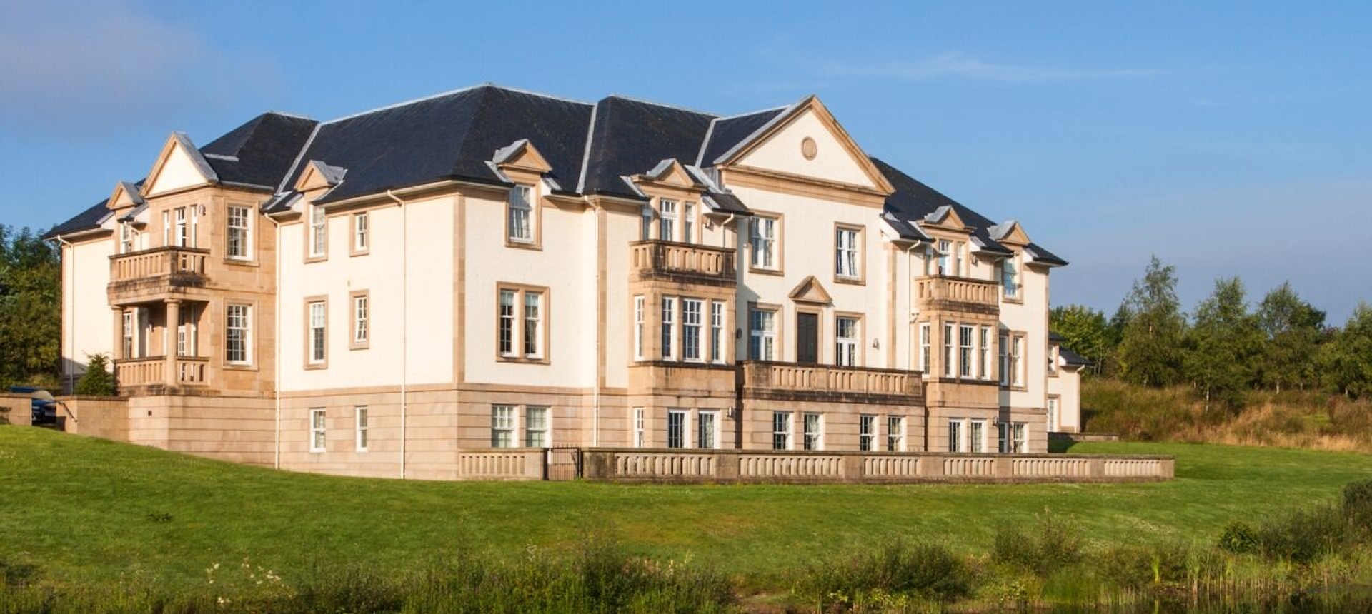 Exterior of Mansion House Suite reflected in a pond