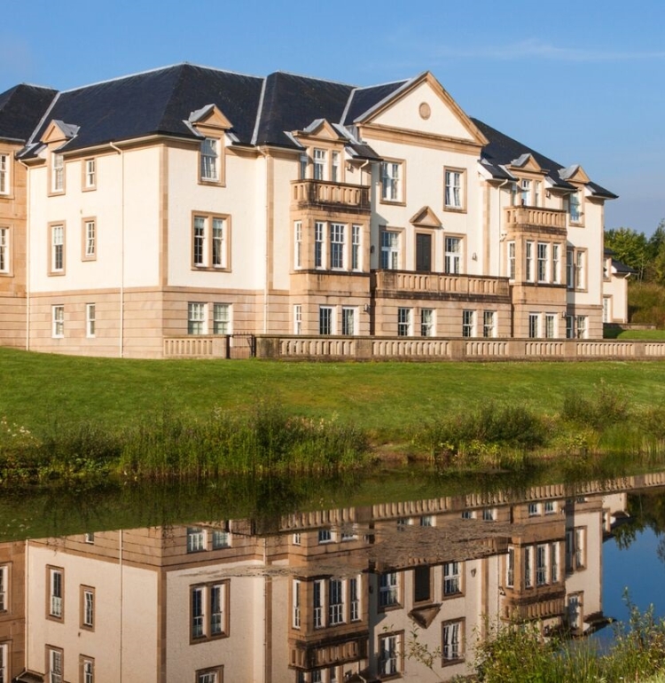 Exterior of Loch Lomond Apartments reflected in a nearby pond.