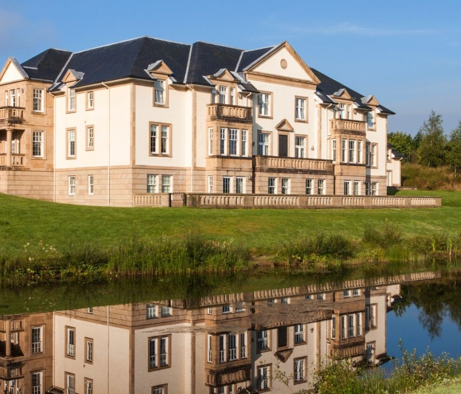 Exterior of Mansion House Suite reflected in a pond