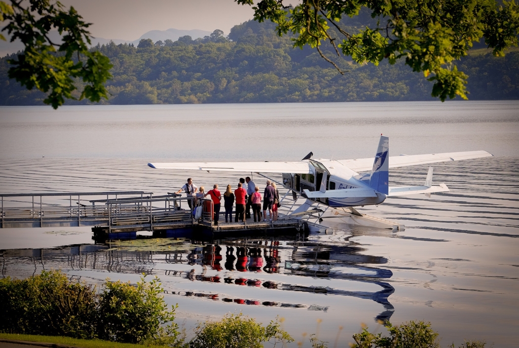 People standing on dock next to plane, ready for adventure.