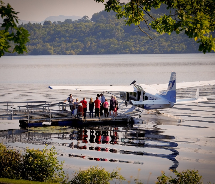 People standing on dock next to plane, ready for adventure.