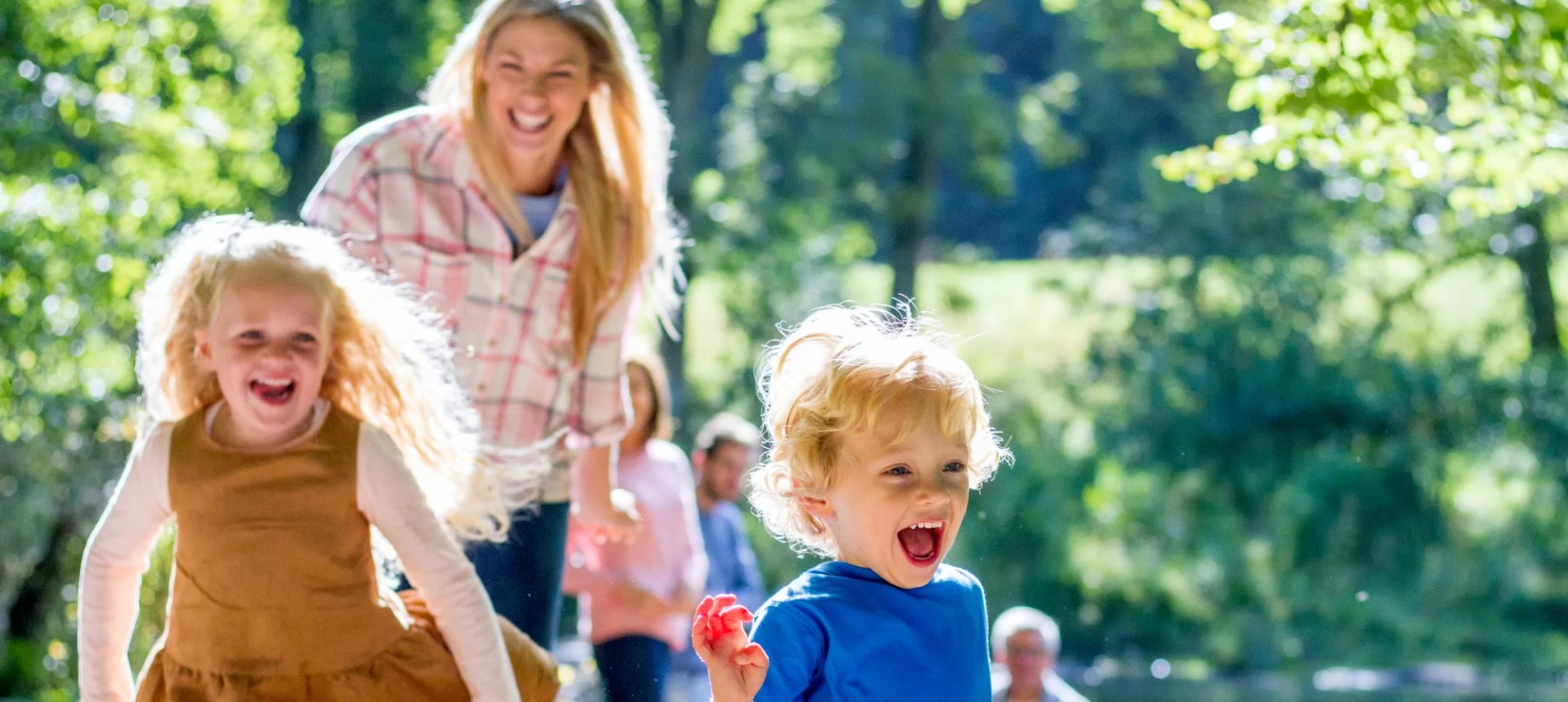 a mother walking outdoors with two children