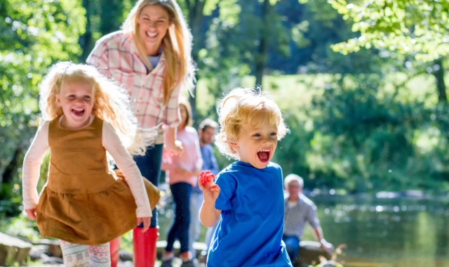 a mother walking outdoors with two children