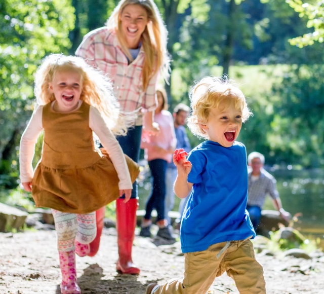 a mother walking outdoors with two children