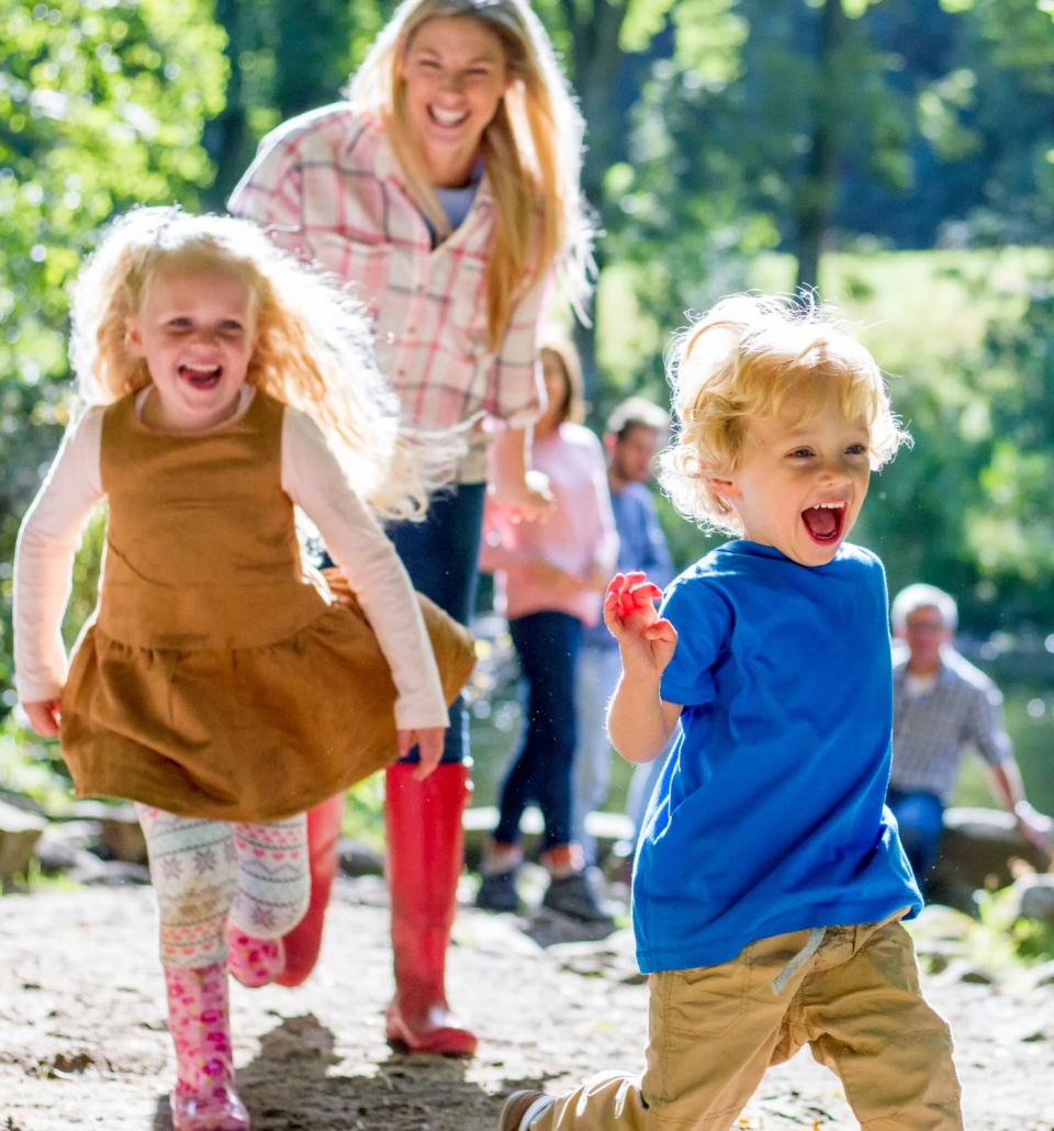 a mother walking outdoors with two children