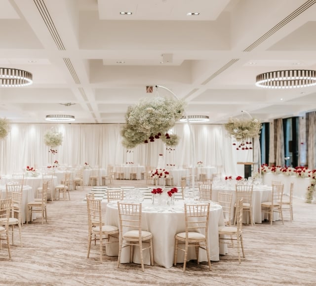 Ballroom with chairs and tables decorated with floral centrepieces